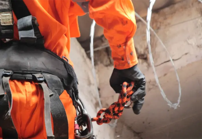Profissional com cinto de segurança e equipamento de acesso por cordas
